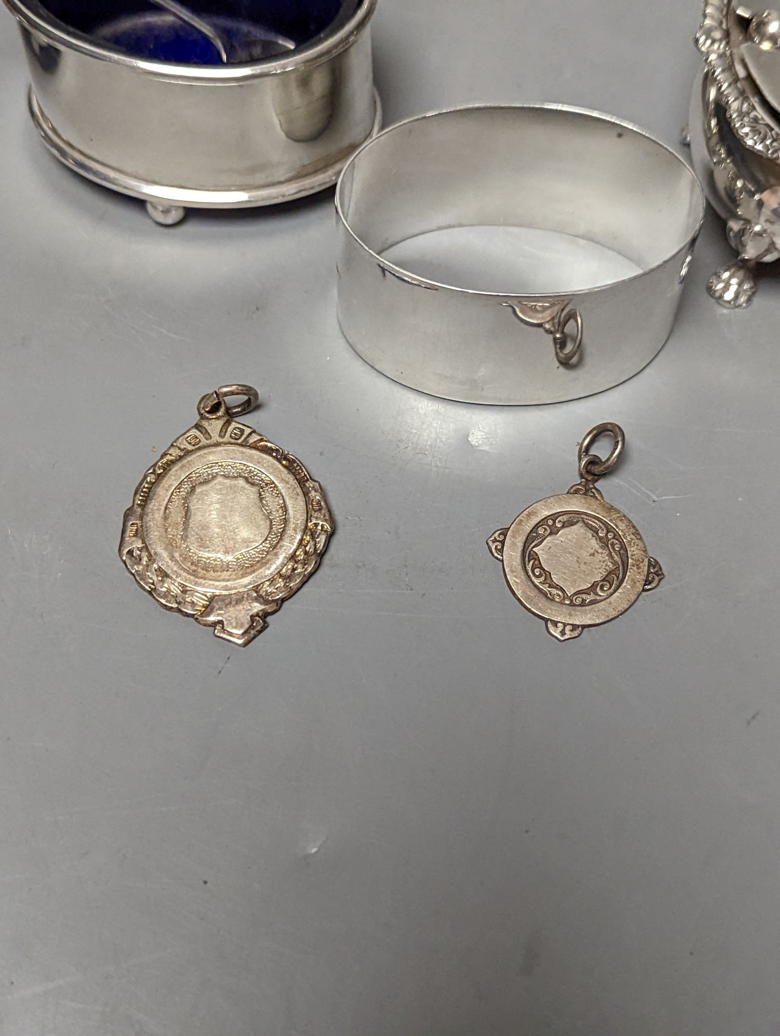 A late Victorian small silver condiment stand with three glass condiments, London, 1883, 49mm, other minor condiments and a silver sugar caster.
